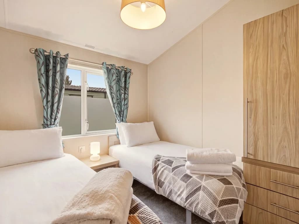 Twin bedroom with two single beds, wardrobe and bedside lighting