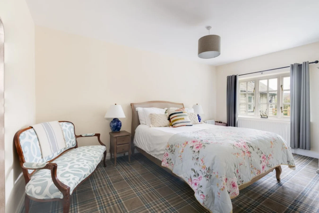 Peaceful king bedroom with floral linens and countryside charm