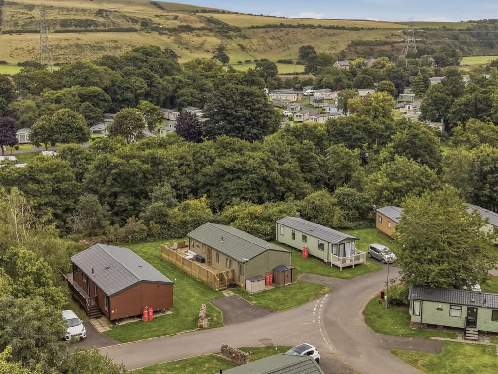 Aerial view of Cheviot Retreat Lodge among trees within the holiday park