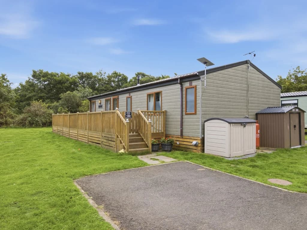 Exterior of the lodge with private parking space and wraparound decking