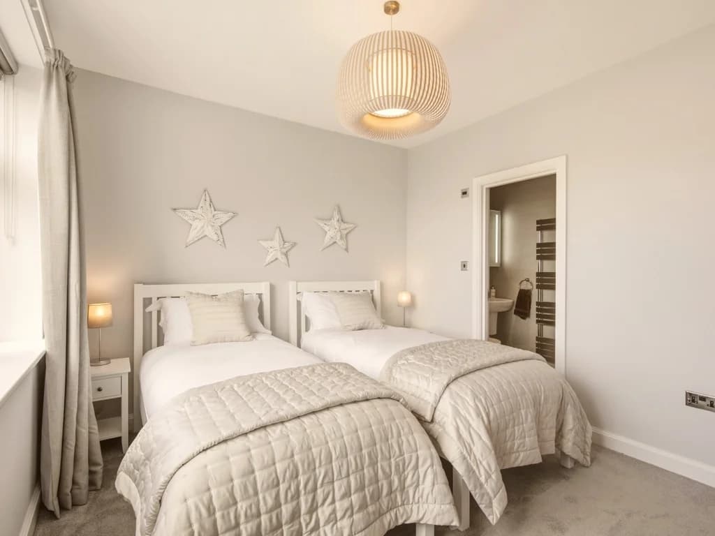 Bright twin bedroom with coastal-inspired décor and comfortable single beds