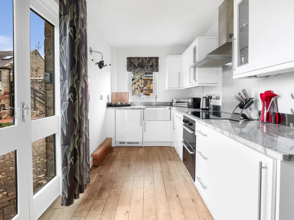 Contemporary kitchen with white cabinetry and granite countertops