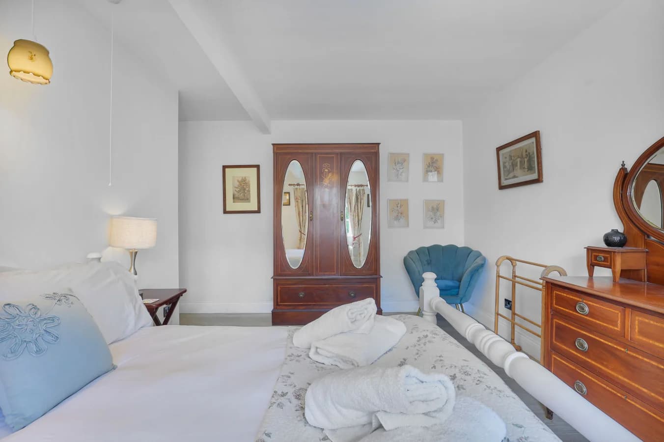 Double bedroom with brass bedframe and antique wardrobe