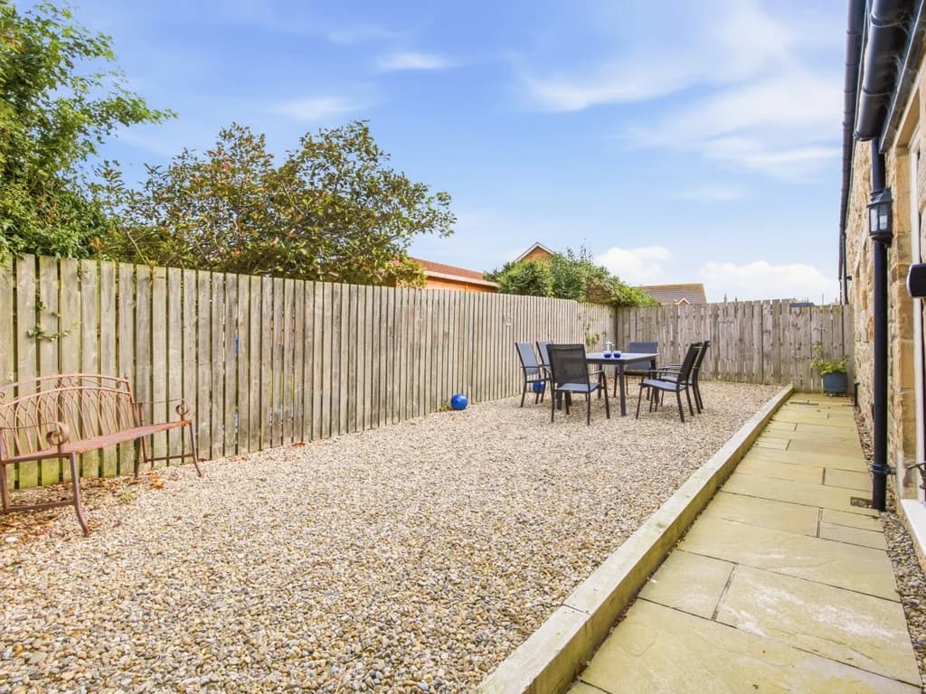Spacious enclosed garden with outdoor dining area beside the house