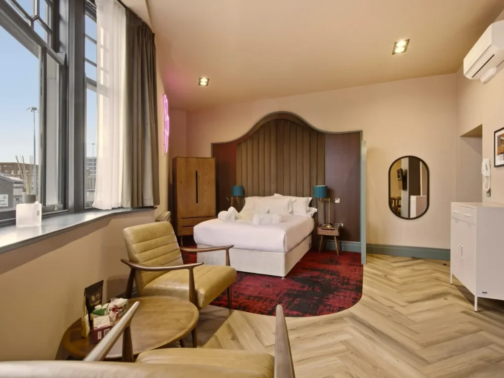 Bright open-plan studio with bay windows, seating and double bed.