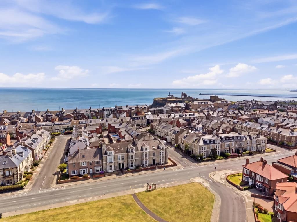 Aerial view across Tynemouth rooftops towards the Priory and coast.