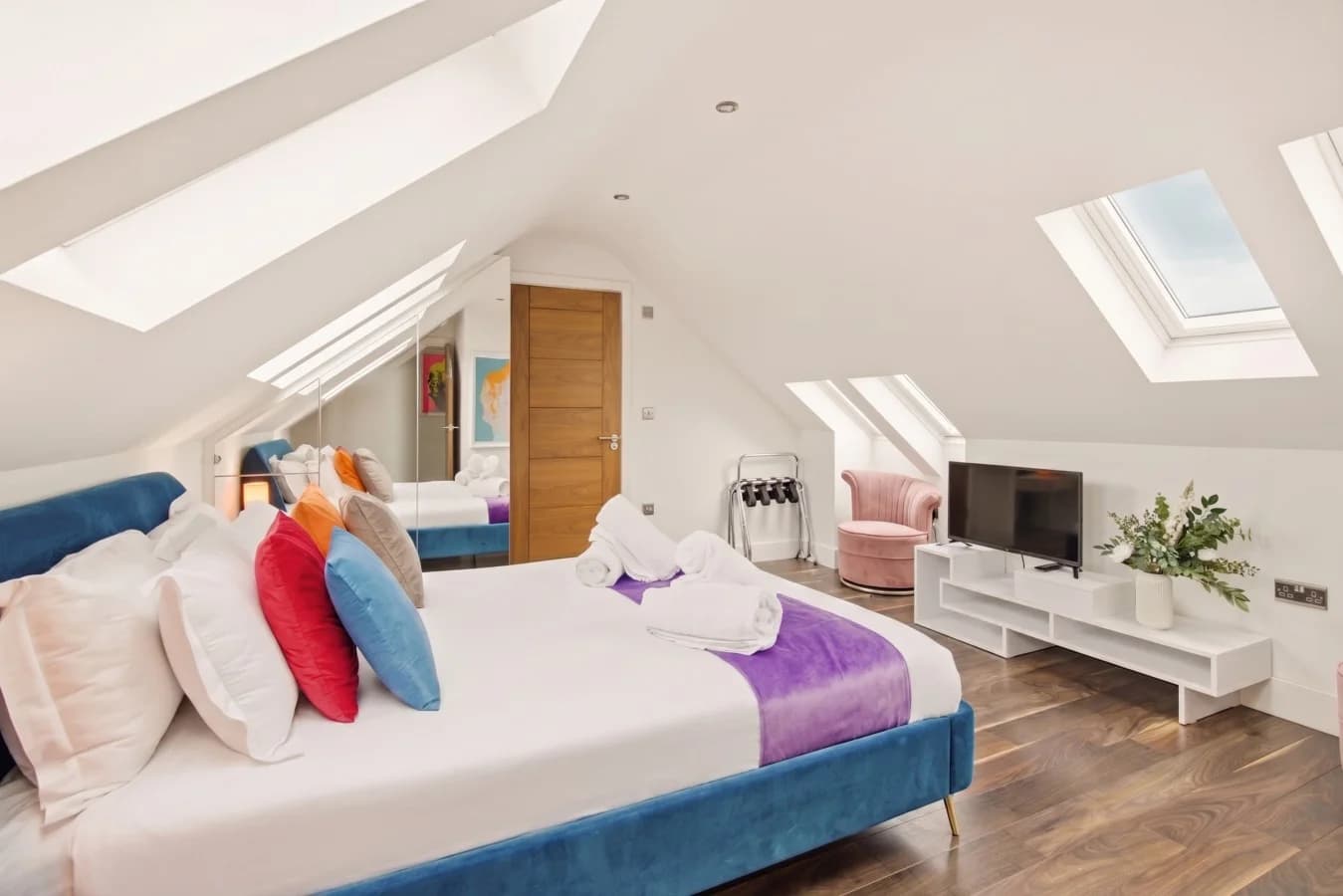 Super-king bedroom with turquoise headboard and vaulted ceiling