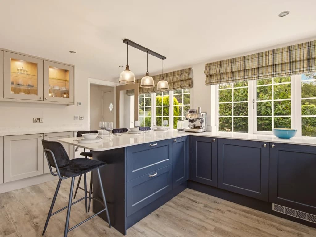 Contemporary kitchen with navy cabinetry, breakfast bar and garden views