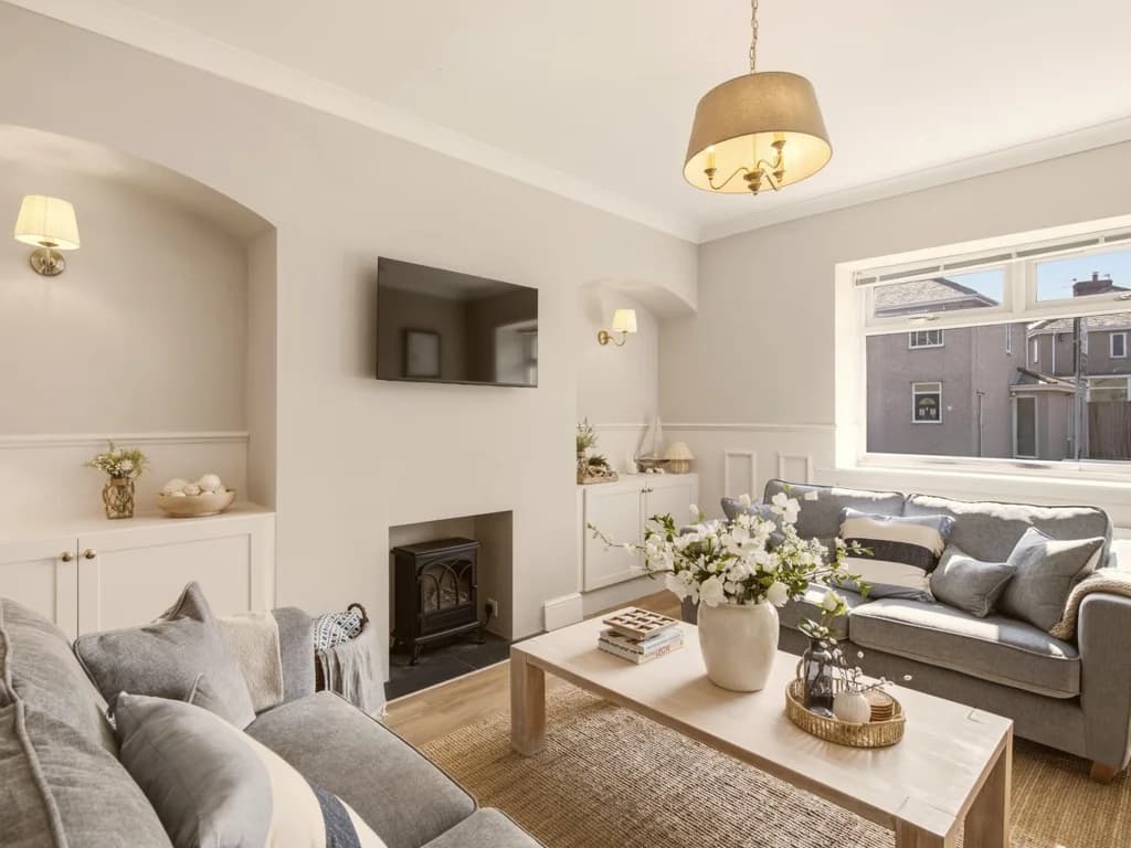 Bright lounge with grey sofas, feature fireplace and Smart TV