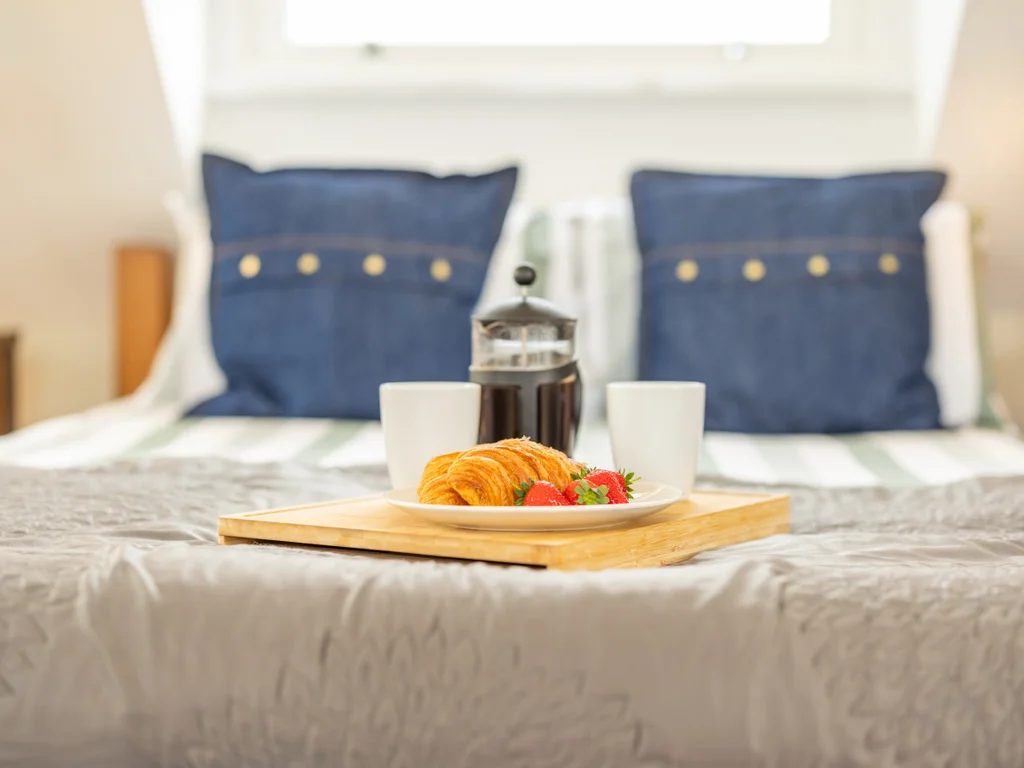 Continental breakfast served in bed — croissants, fruit and fresh coffee.