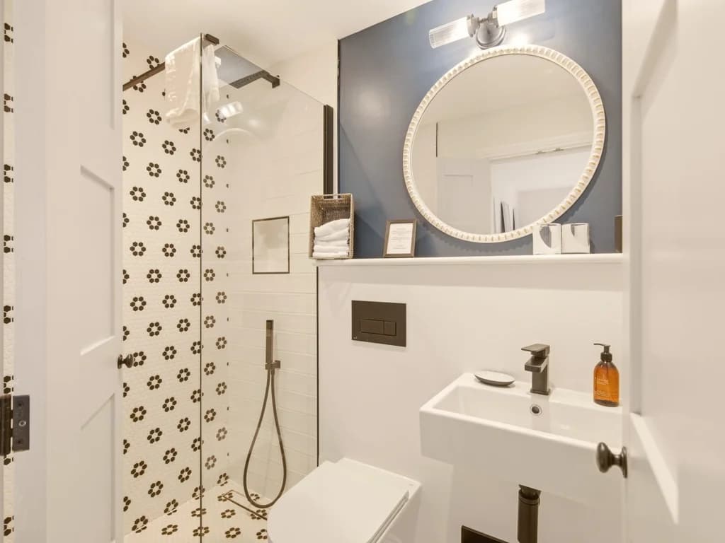 En-suite shower room with patterned feature tiles and floating vanity unit