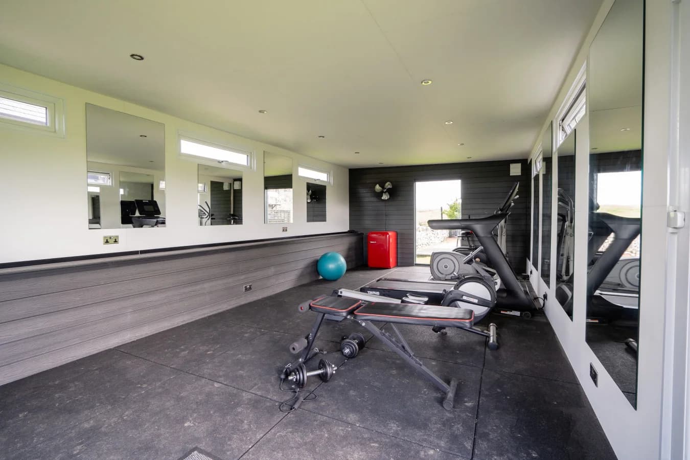 Shared gym with mirrored walls and exercise equipment