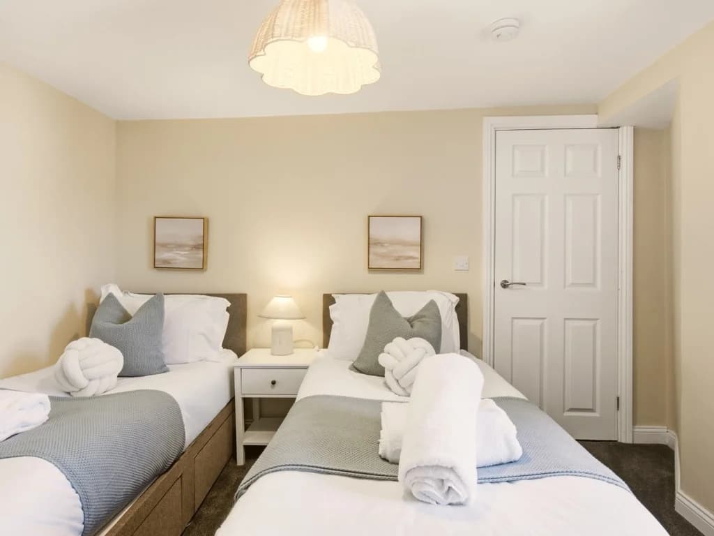 Bright twin bedroom with bedside table and coordinating artwork.