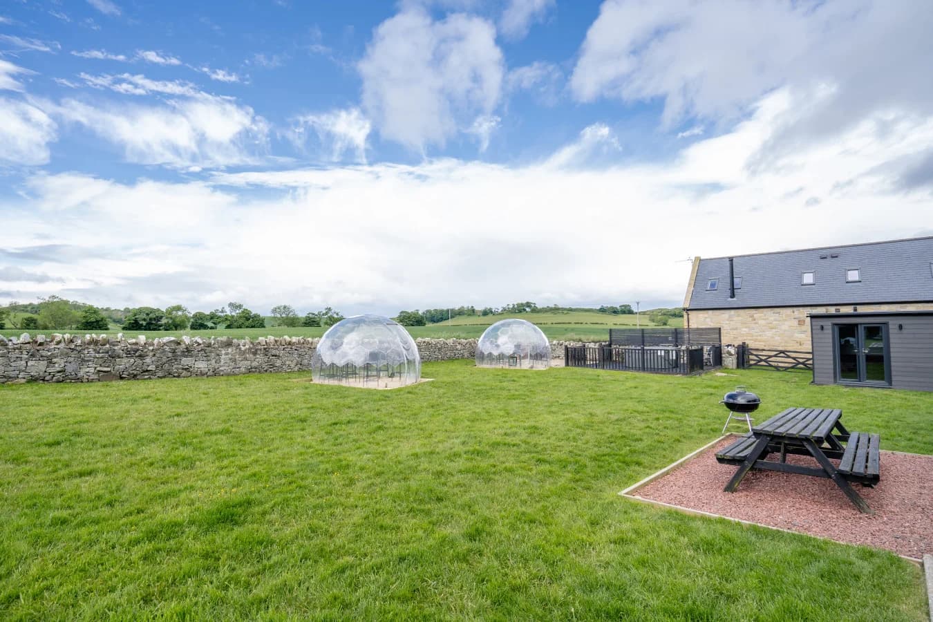Shared grassed paddock with dining pods and picnic bench