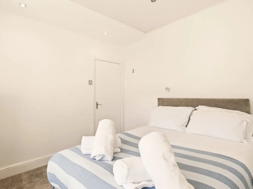 Double bedroom with upholstered headboard and soft neutral décor.