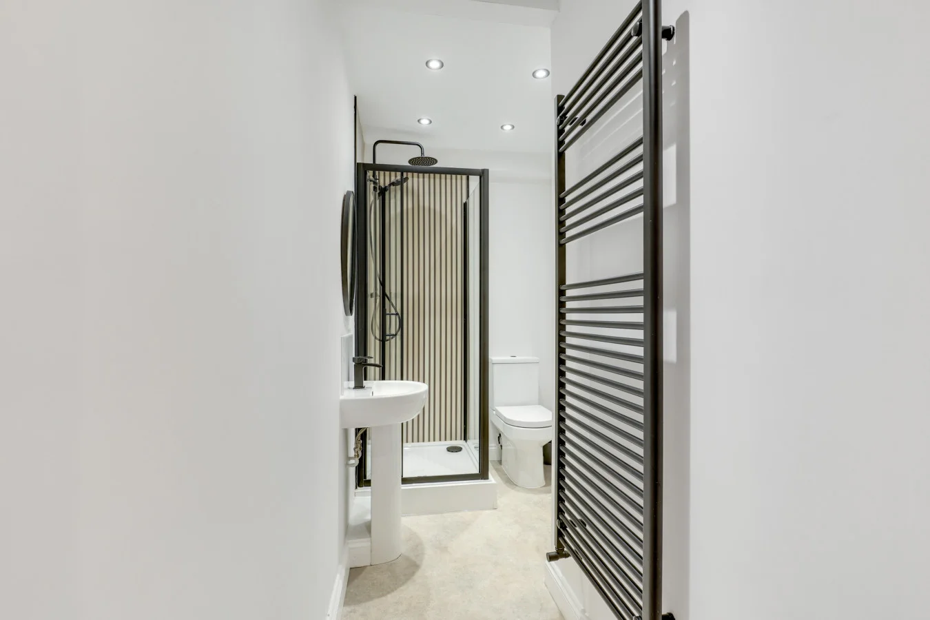 Contemporary bathroom with black heated towel rail and minimalist styling