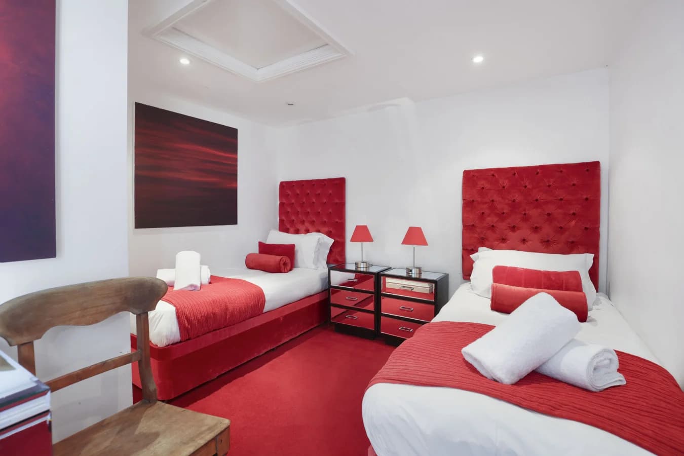 Twin bedroom with red upholstered headboards