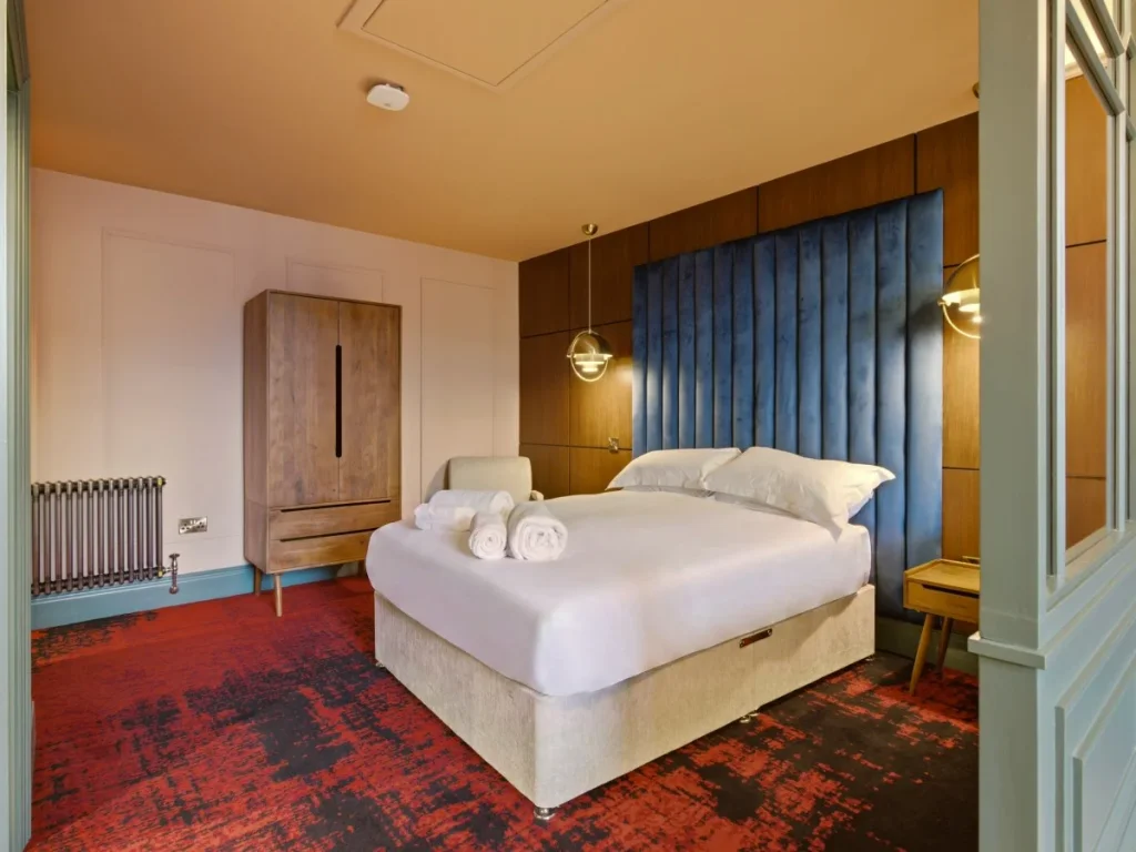 Bedroom area with double bed, storage and warm bedside lighting.