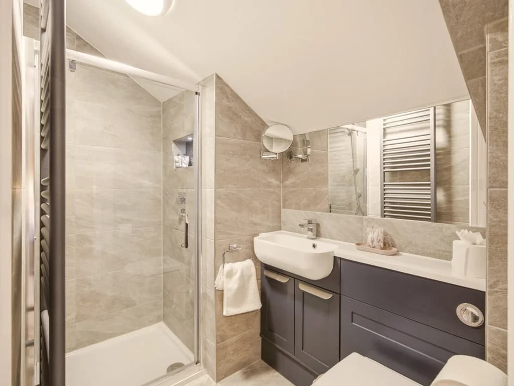 Stylish en-suite shower room with contemporary vanity unit and walk-in shower.