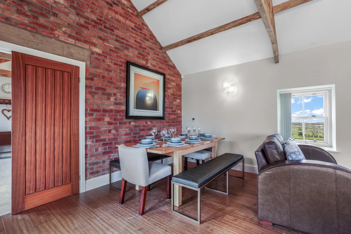 Dining area with countryside views and rustic brick feature wall