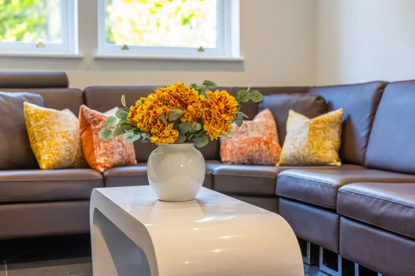Corner sofa with patterned cushions and glossy coffee table