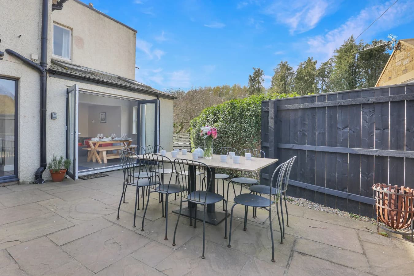 Private patio with outdoor dining furniture beside the house