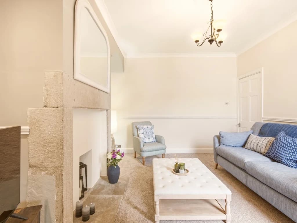 Bright lounge with feature fireplace and upholstered armchair.