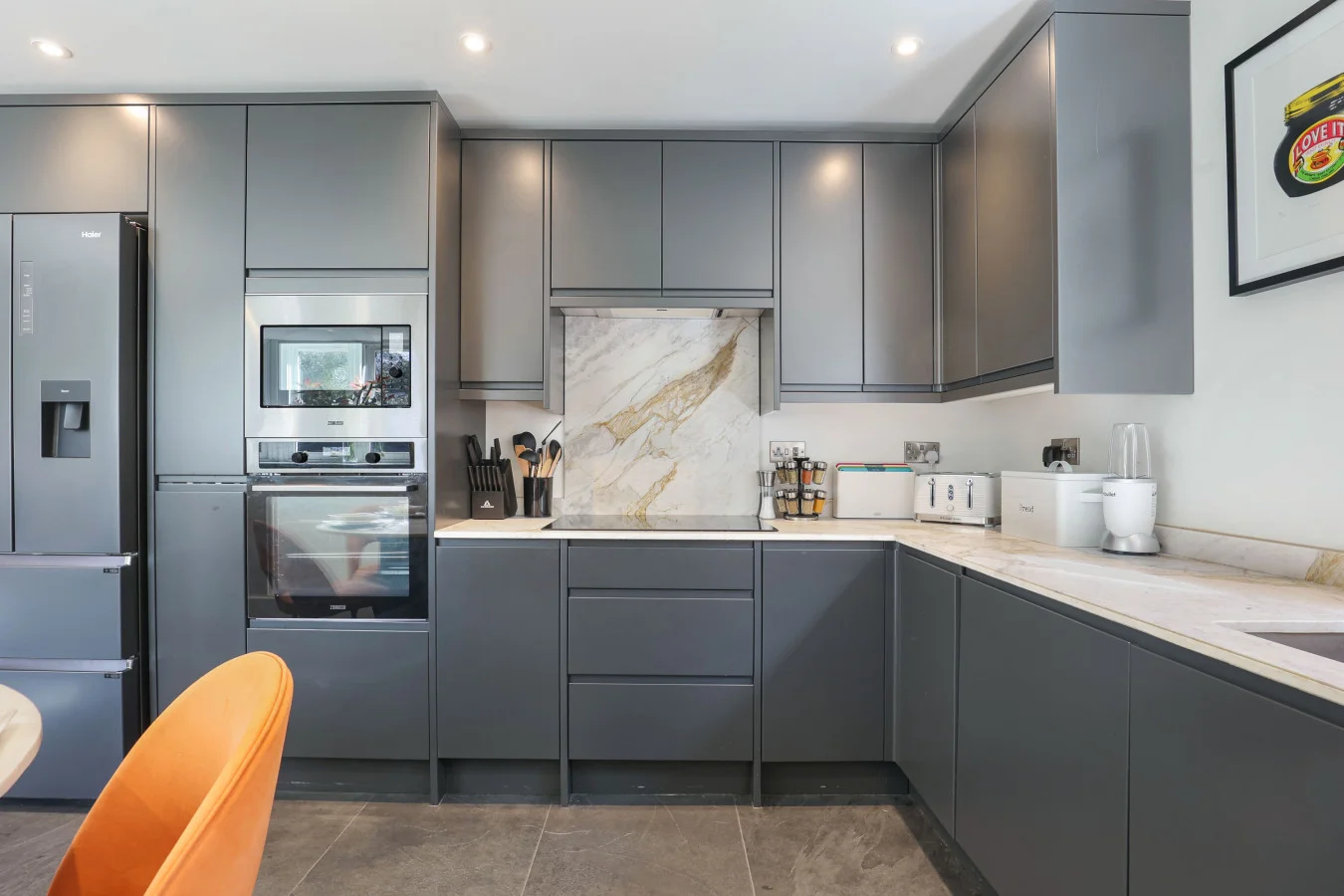 Contemporary kitchen with grey cabinetry and marble-effect splashback