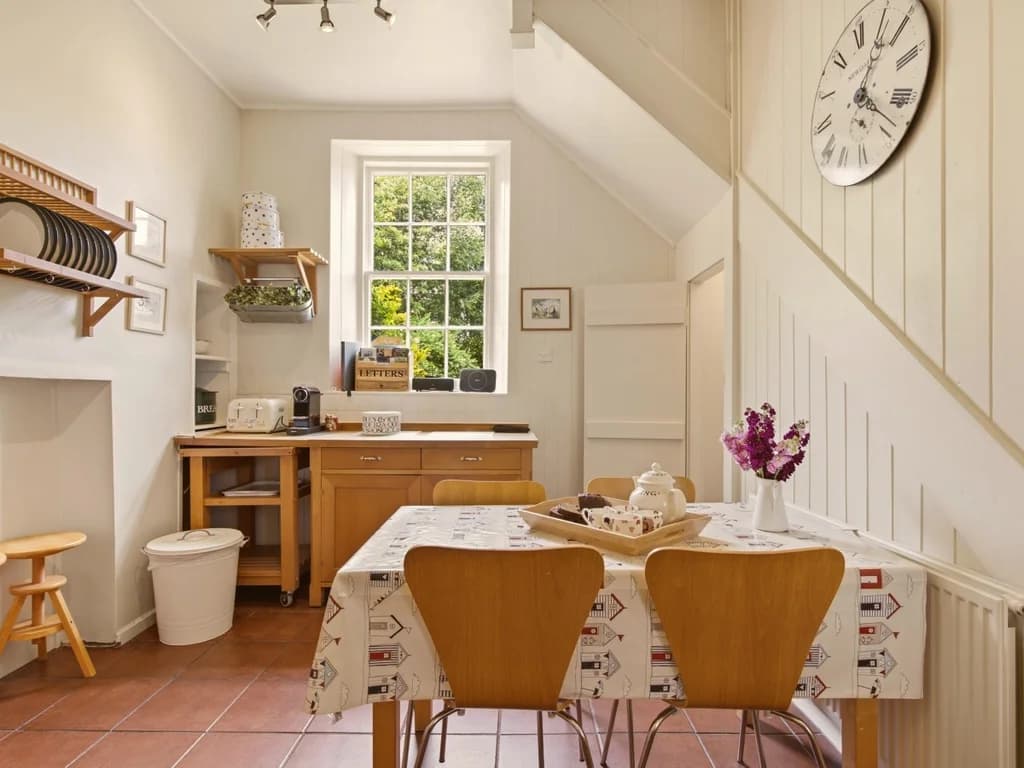 Bright farmhouse kitchen with breakfast table and large sash window