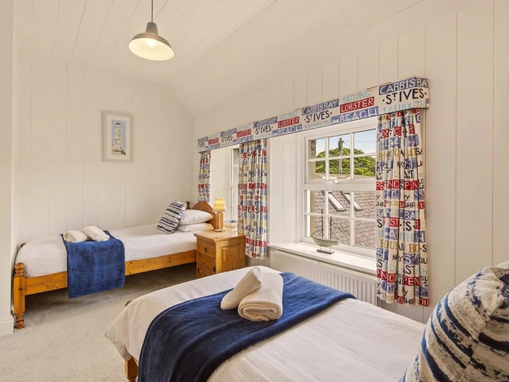 Bright twin bedroom with colourful coastal décor and large sash windows
