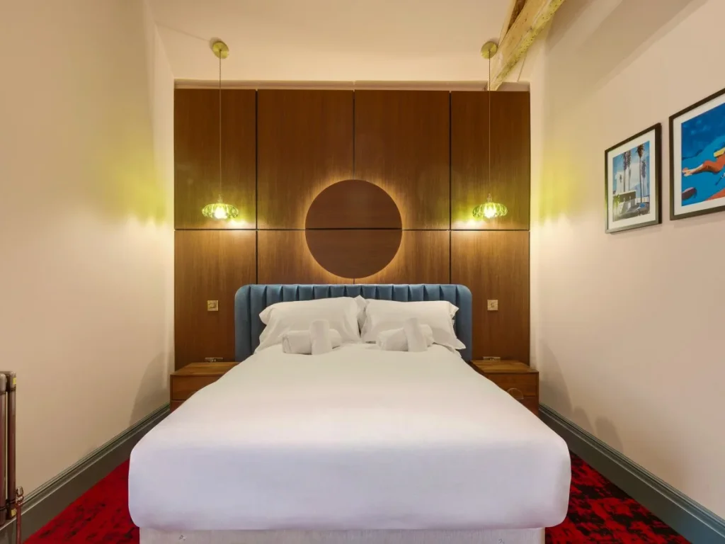 Double bedroom with wood-panelled headboard and warm bedside lighting