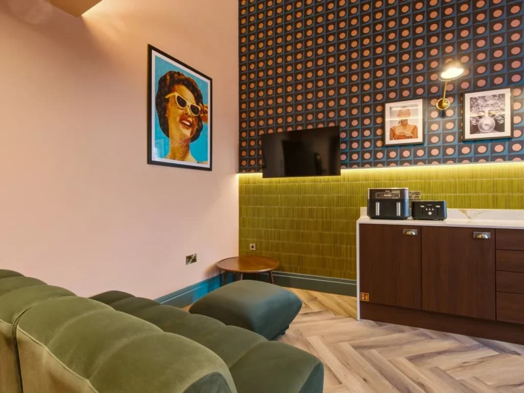 Lounge seating facing the kitchenette with patterned wall and artwork
