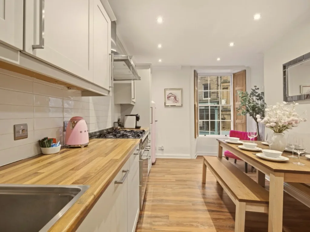 Bright kitchen and dining space with wooden table and bench seating.