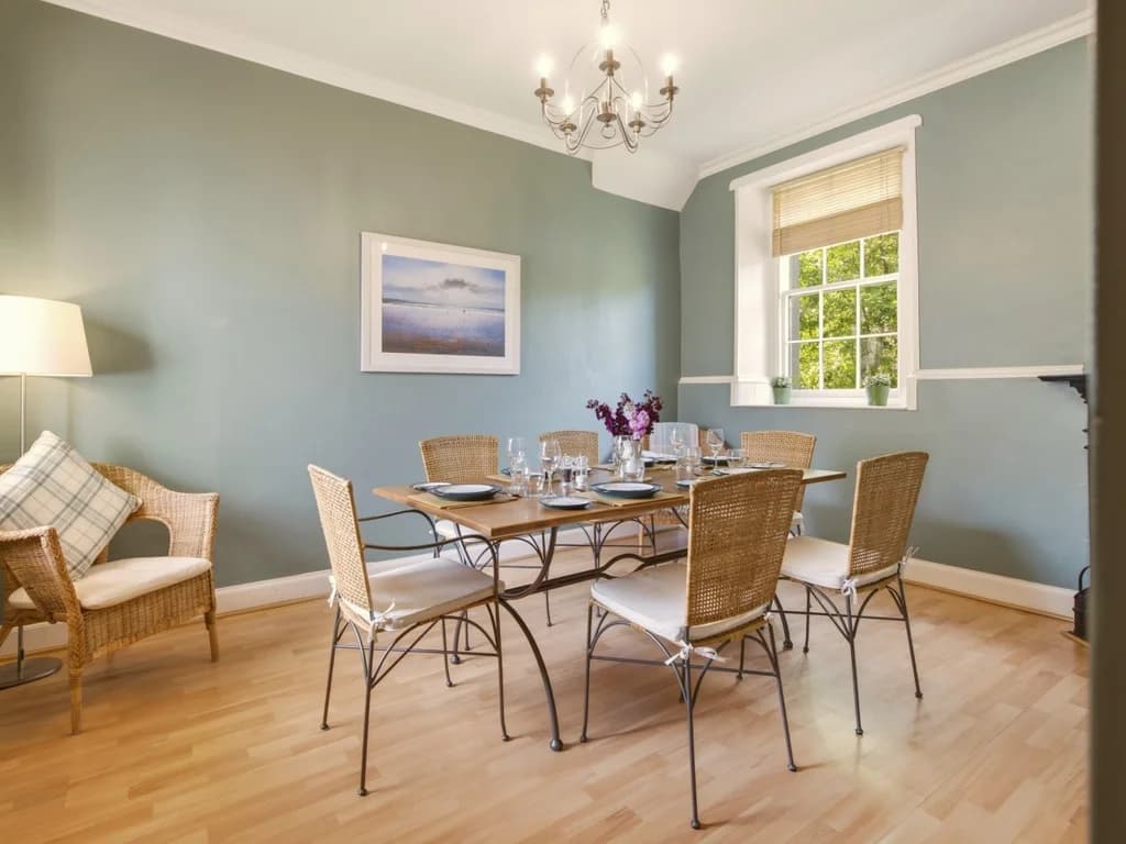 Elegant dining room with wicker seating and table set for six guests