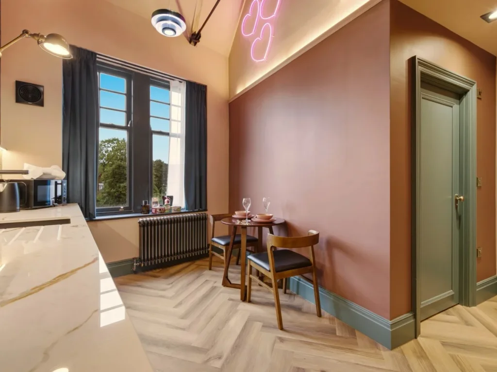 Dining area beside the window with kitchenette and neon heart detail