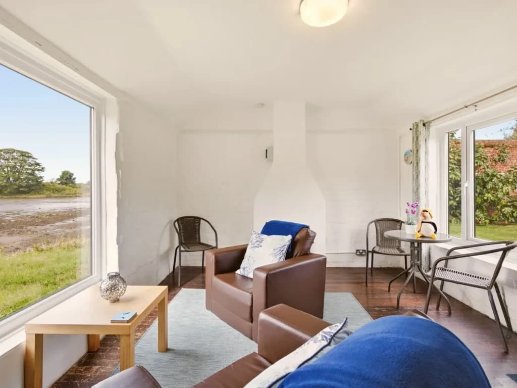 Jetty Cottage lounge with comfortable seating and waterside views