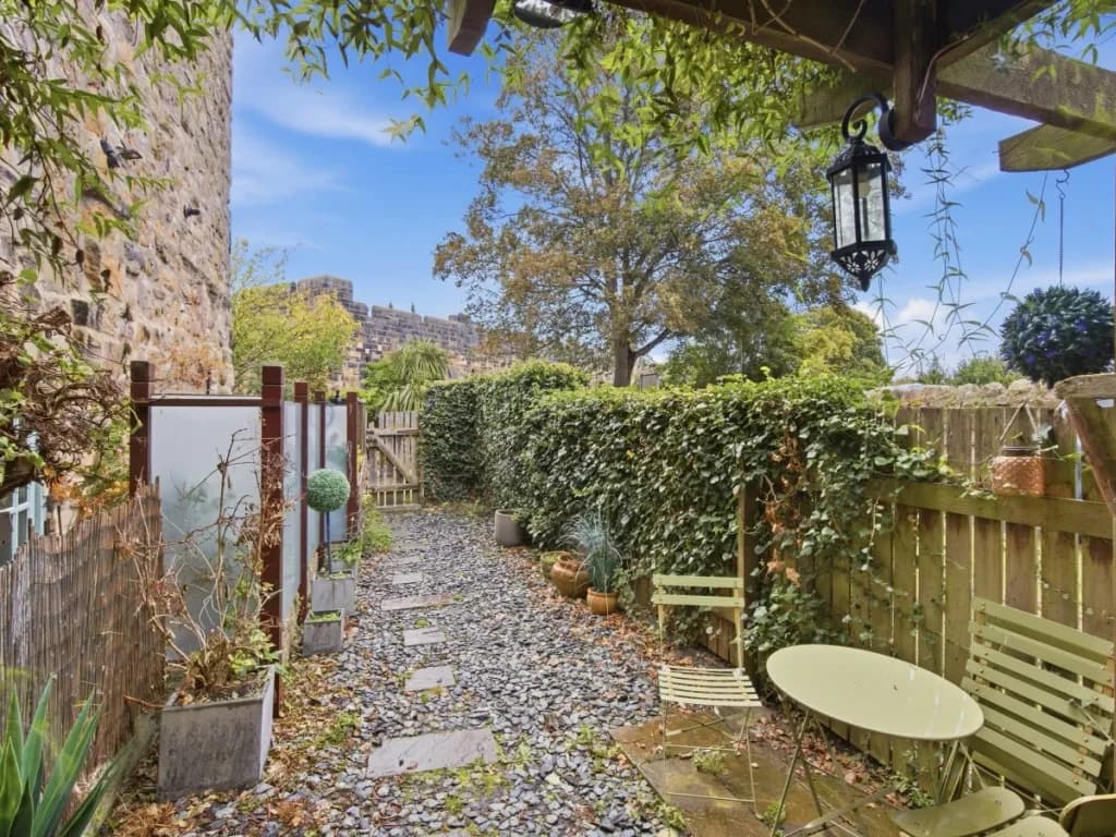 Fenced backyard with outdoor seating and views towards Alnwick Castle.
