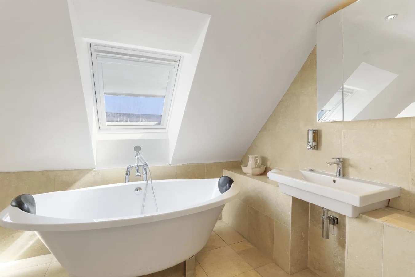 Family bathroom with freestanding bath and travertine tiles