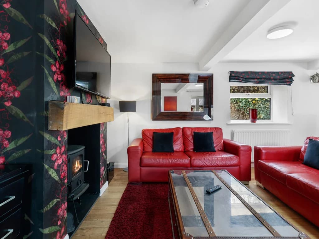 Red leather seating around the log burner and coffee chest
