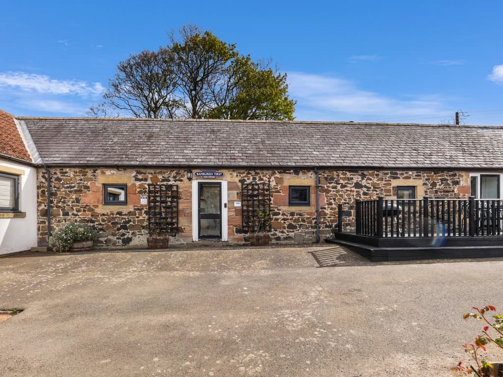 Stone-built exterior of the cottage within the shared courtyard