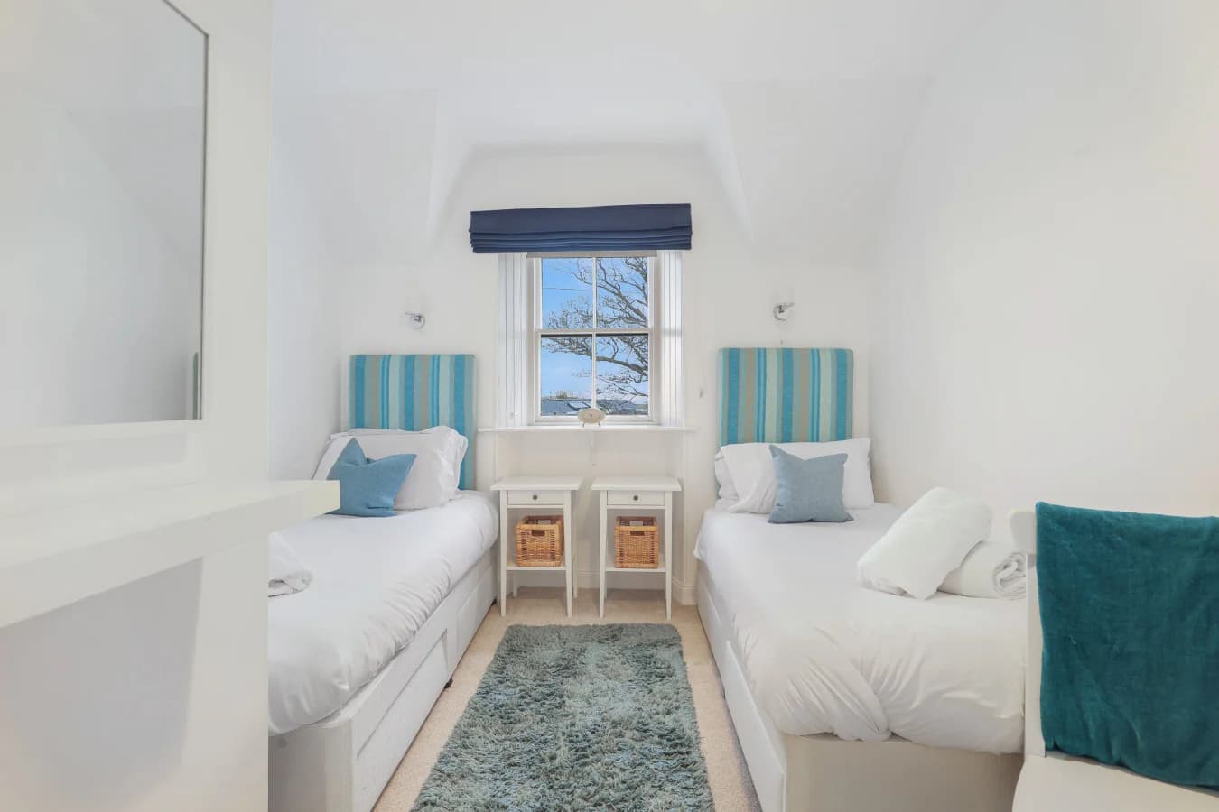 Twin bedroom with striped headboards and central window