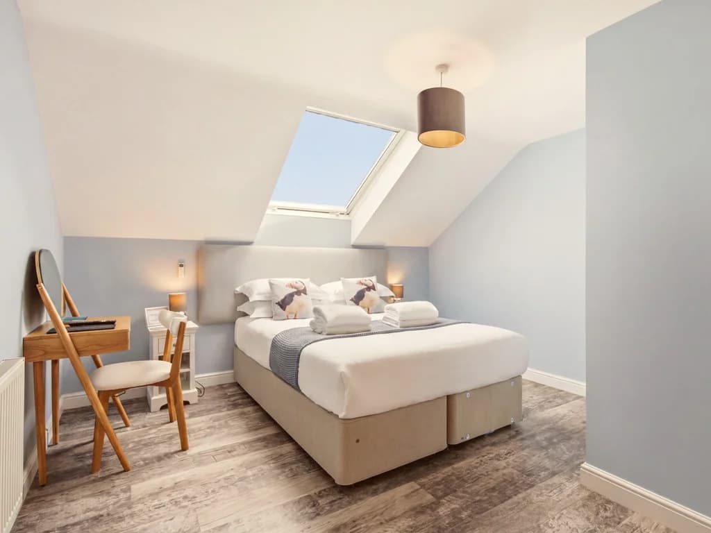 Spacious king-size bedroom with skylight, dressing table and chair