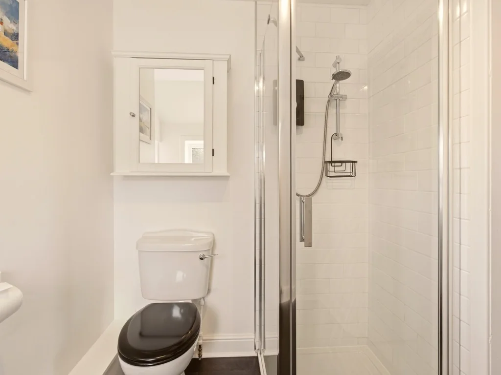 Contemporary en-suite shower room with white metro tiles and heated towel rail