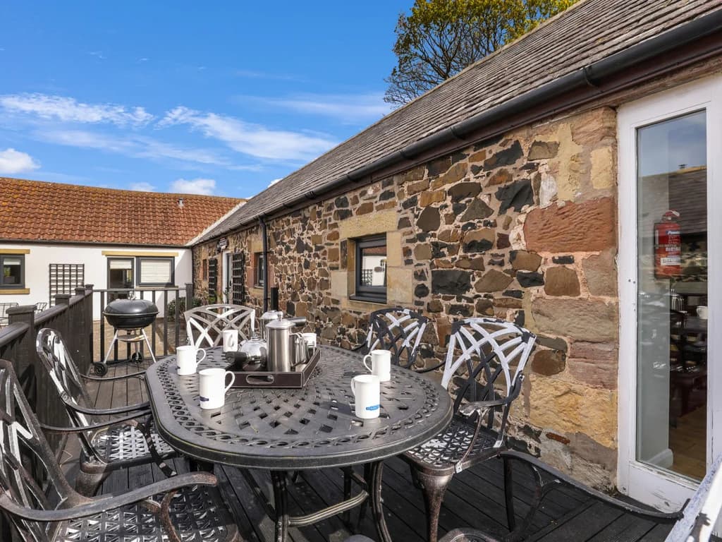 Courtyard patio with cast-iron dining set and barbecue