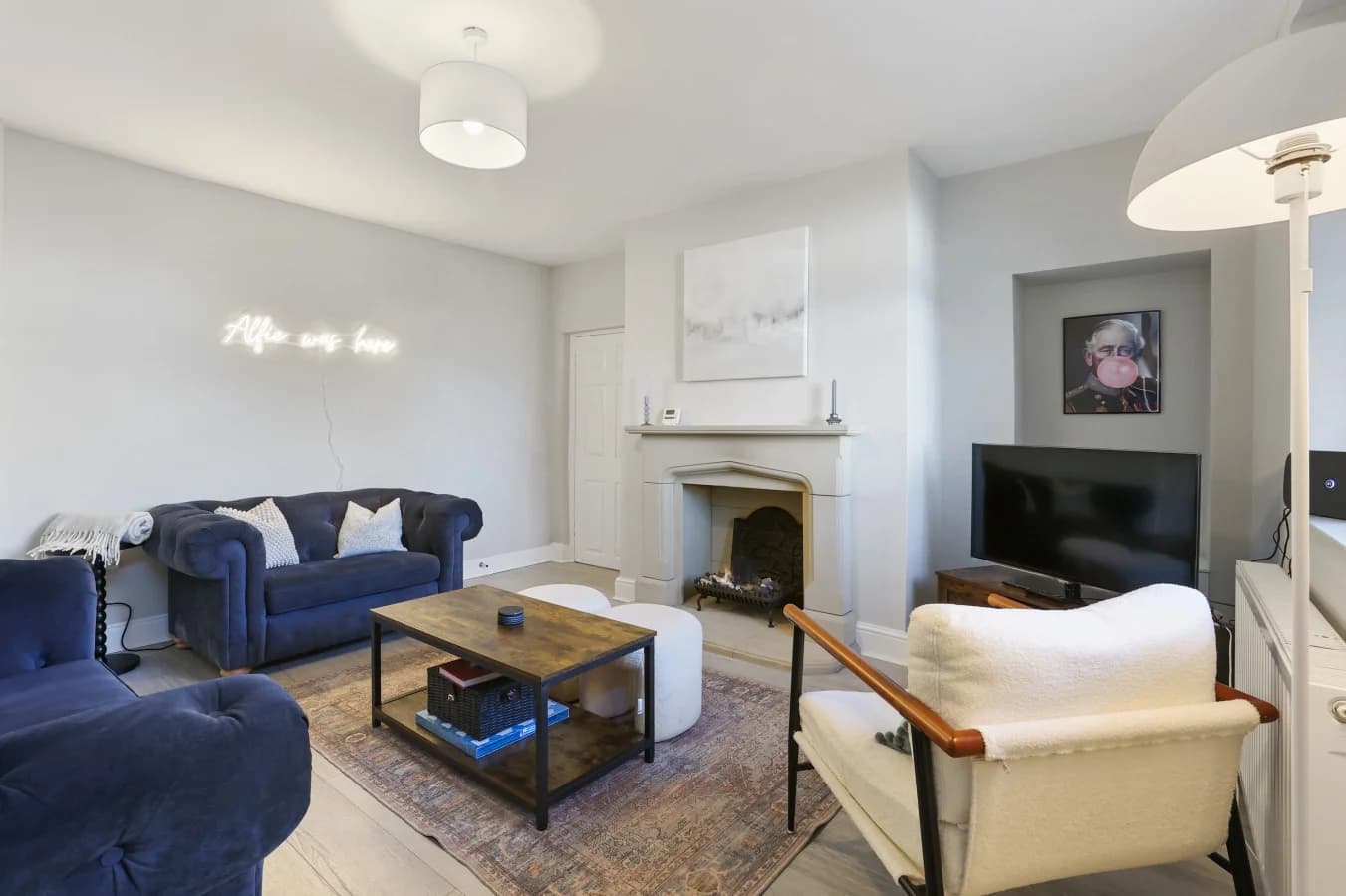 Characterful lounge with deep blue sofas, period fireplace and TV