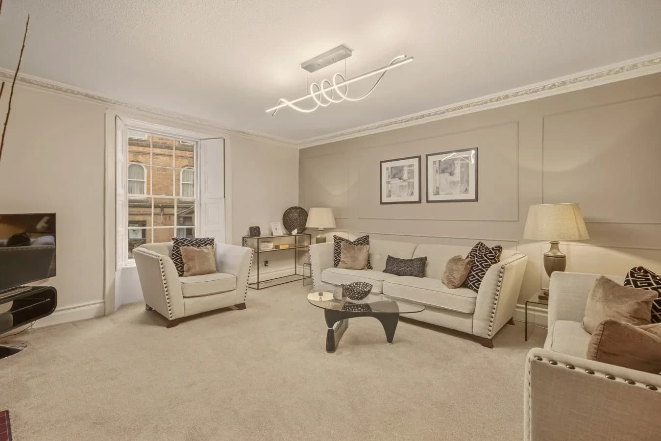 Bright living room with cream seating, soft lighting and classic details.