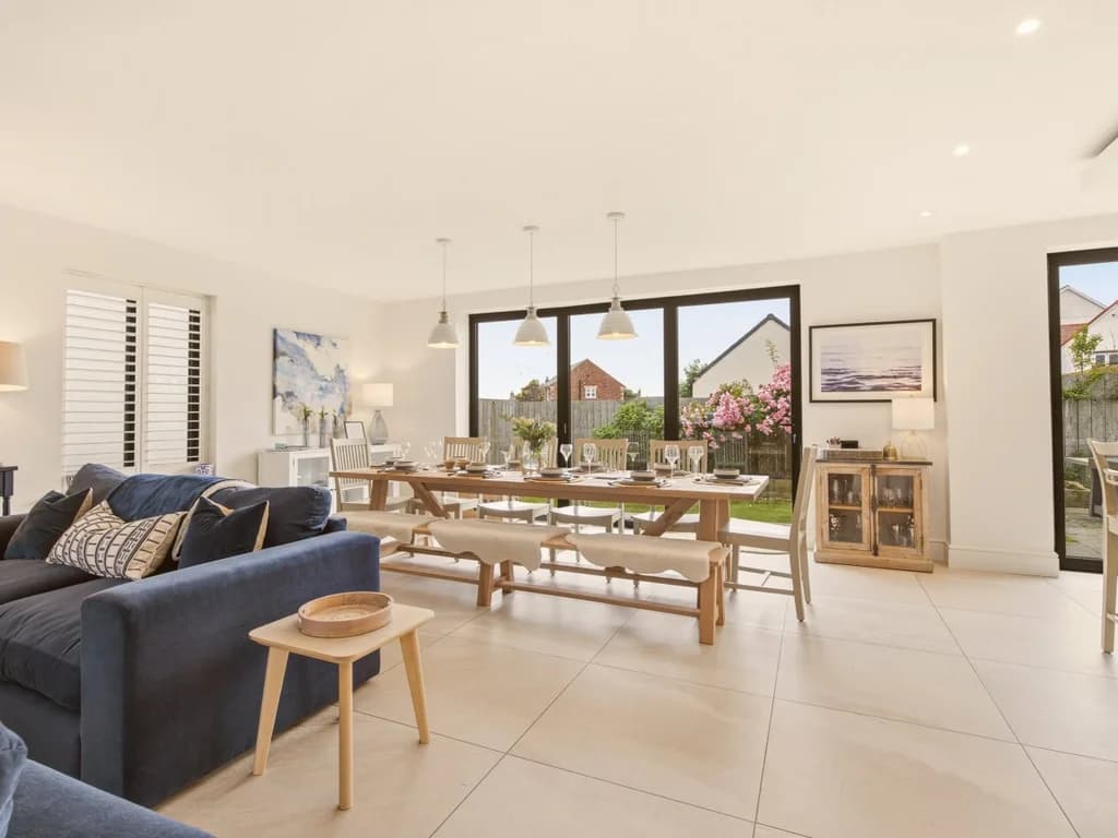 Open-plan living and dining area with bench seating and sliding garden doors