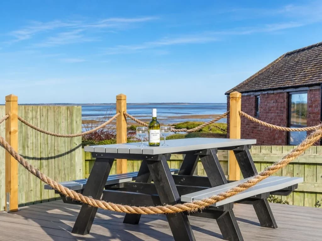 Decked seating area with picnic bench overlooking Budle Bay