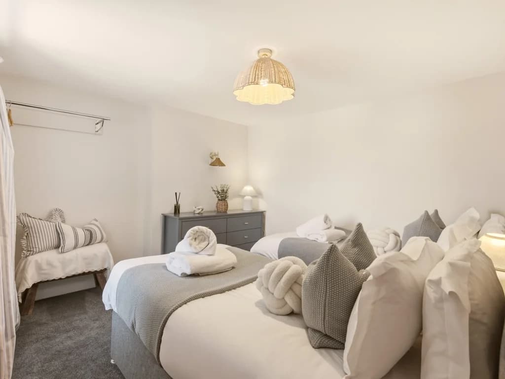 Spacious twin bedroom with matching beds and soft neutral furnishings.