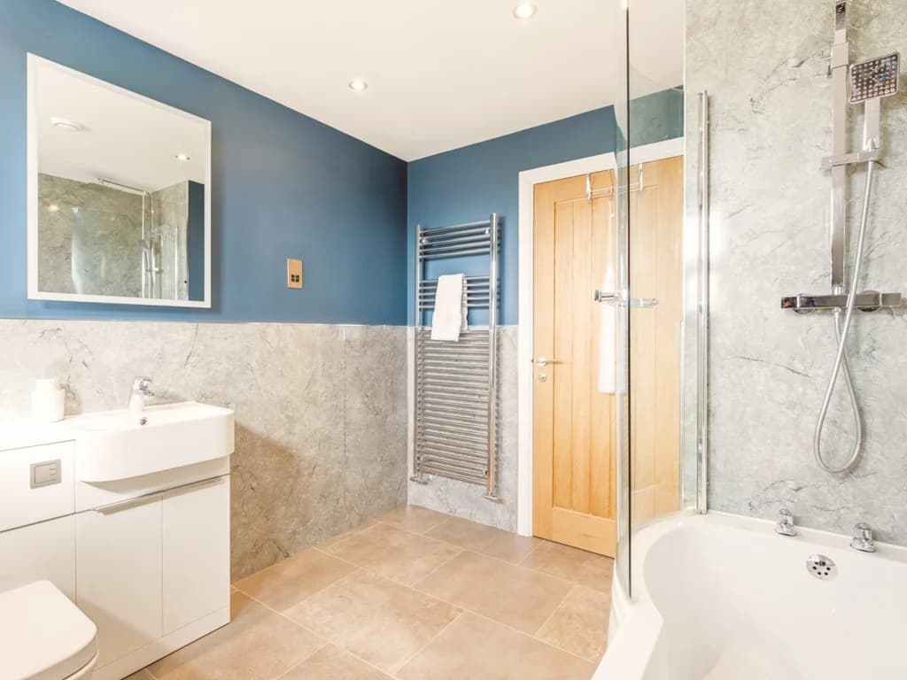 Modern family bathroom with bath, overhead shower and heated towel rail